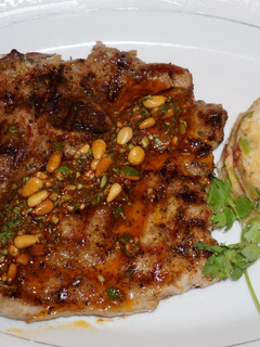 Una foto de Chuletas de cerdo grilladas con chimichurri de piñonesy timbal de porotos blancos