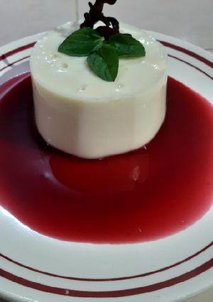 Una foto de Panna cotta de coco con coulis de jamaica y mezcal