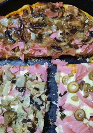 Una foto de Pizza con alcuciles, hongos, jamón y cebolla