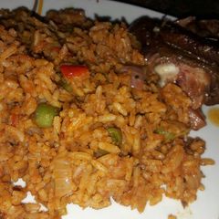 A picture of Jollof Rice and Smoked Chicken.