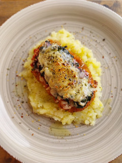 Una foto de Pollo a la parmesana con espinacas y olivas kalamata