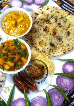 A picture of Butter paneer with naan and aloo gravy.