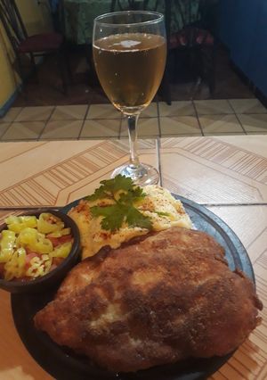 Una foto de Escalopa de pollo apanada con puré cremoso y una ensaladita pica