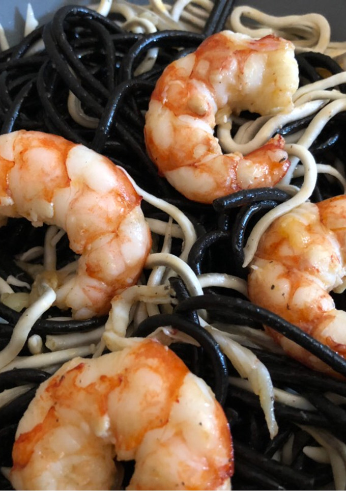 Una foto de Espaguetis negros con gulas y gambas al ajillo