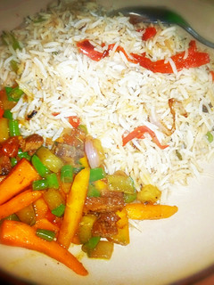 A picture of Chinese rice nd veggies are sauce.