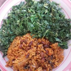 A picture of Spinach and palm oil rice with beans.
