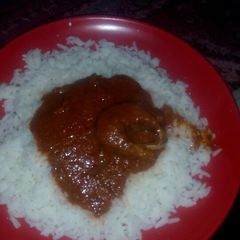 A picture of White rice and palm oil stew.