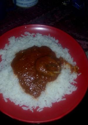 A picture of White rice and palm oil stew.
