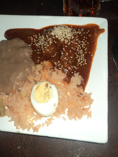 Una foto de Mole de nuez ranchero para fiesta con frijoles enchilados y arroz con huevos duros