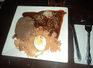 Una foto de Mole de nuez ranchero para fiesta con frijoles enchilados y arroz con huevos duros