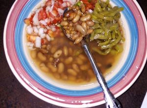 Una foto de Frijoles de la olla y trigo con nopales cocidos en pulque, epazote y xoconostle con pico de gallo