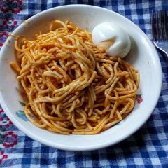 A picture of Simple jollof spaghetti and hard boiled egg.