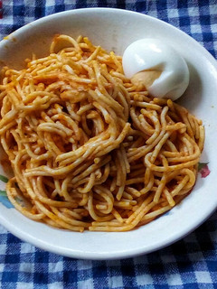 A picture of Simple jollof spaghetti and hard boiled egg.