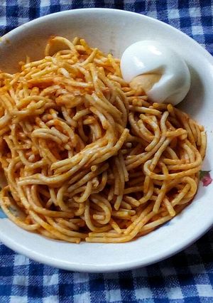 A picture of Simple jollof spaghetti and hard boiled egg.