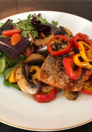 A picture of Grilled Salmon with Sautéed Mushrooms mixed Bell Peppers, and Greens Salad used BBQ Sauce.