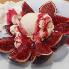 A picture of Figs and Raspberry Coulis with Ice Cream and Cream.