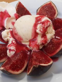 A picture of Figs and Raspberry Coulis with Ice Cream and Cream.