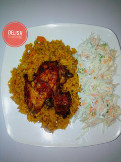 A picture of Jollof rice, coleslaw and peppered chicken.