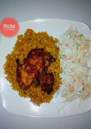 A picture of Jollof rice, coleslaw and peppered chicken.