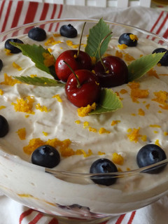 Una foto de Postre de mango con cerezas frescas y crema especial