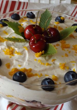 Una foto de Postre de mango con cerezas frescas y crema especial