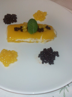 Una foto de Arroz con leche con geleé de mango, caviar de chocolate y perlas de mango