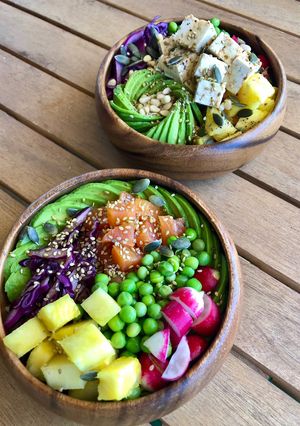 Une photo de Poke bowl de saumon, ananas, avocat, choux, petits pois, radis