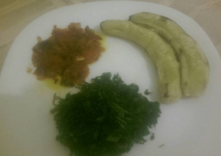 Matoke served with steamed spinach and tomato paste