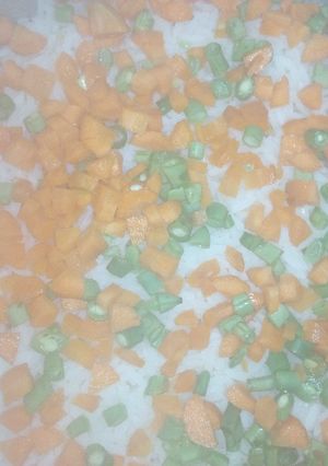 A picture of White rice with carrot and green beans.