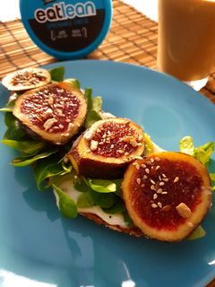 Una foto de Tostada con queso, higos y canónigos