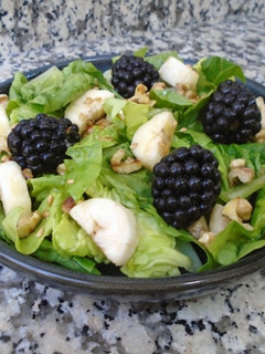Una foto de Cogollos de lechuga con nueces, plátano y moras