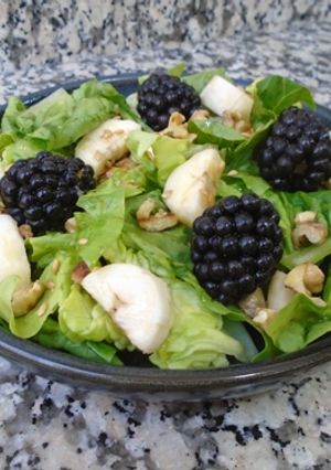 Una foto de Cogollos de lechuga con nueces, plátano y moras