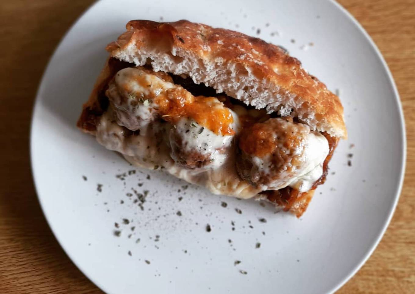 Focaccia con albóndigas, cebolla caramelizada y queso gratinado