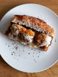 Una foto de Focaccia con albóndigas, cebolla caramelizada y queso gratinado