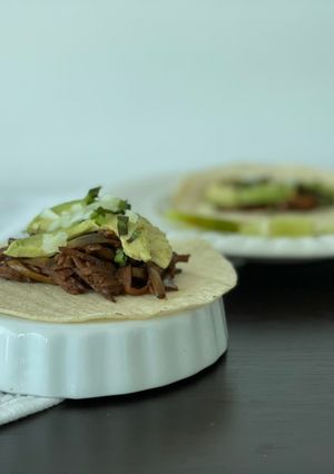 Una foto de Tacos veganos de cáscara de banano guisada a la Puli