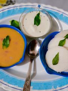 A picture of Idli sambhar with coconut chutney.