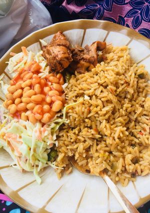 A picture of Jollof rice,salad and grilled chicken.