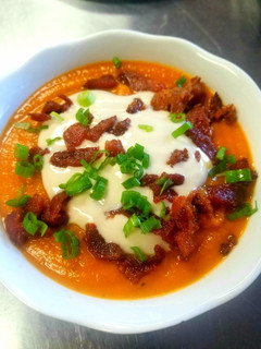 A picture of Sweet Potato Soup With Maple Sour Cream and Candied Bacon.
