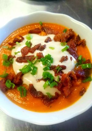 A picture of Sweet Potato Soup With Maple Sour Cream and Candied Bacon.