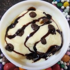 A picture of Vanilla ice cream with chocolates sauce.