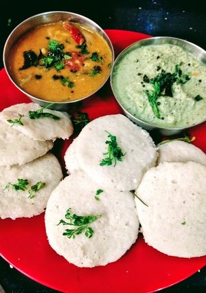 A picture of Steamed Idli with chutney and sambar.