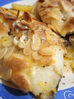 Una foto de Bacalao al Horno con Alioli Gratinado Almendrado y Patatas Provenzales