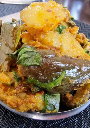 A picture of Stuffed brinjals and potato curry in pressure cooker.