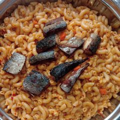 A picture of Jollof macaroni with fried boneless fish.