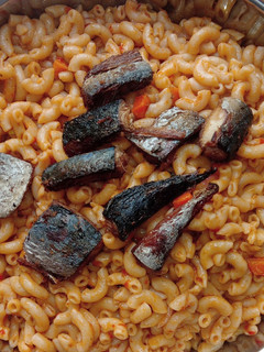 A picture of Jollof macaroni with fried boneless fish.