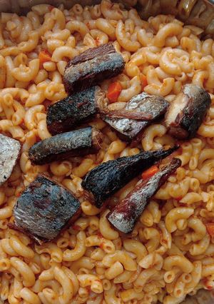 A picture of Jollof macaroni with fried boneless fish.