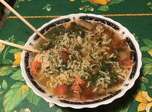 Une photo de Soupe asiatique épicée au bouillon de crevettes, tomate noire, shiitakes et coriandre