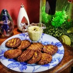 A picture of Shikampoori kabab with chutney.