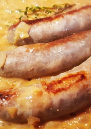 Une photo de Saucisses sauce moutarde et courgettes jaunes.