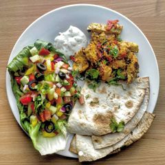 A picture of Chicken tikka kebabs with Indian salad.